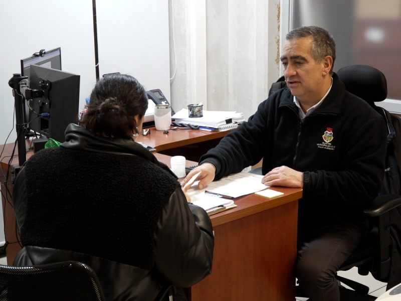 Funcionario municipal atendiendo a una vecina en el edificio consistorial.