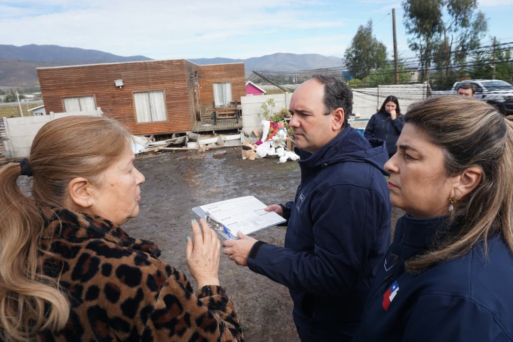El seremi de Desarrollo Social y Familia, Nicolás Cerda, junto a equipos municipales, conversa con una vecina afectada en terreno.