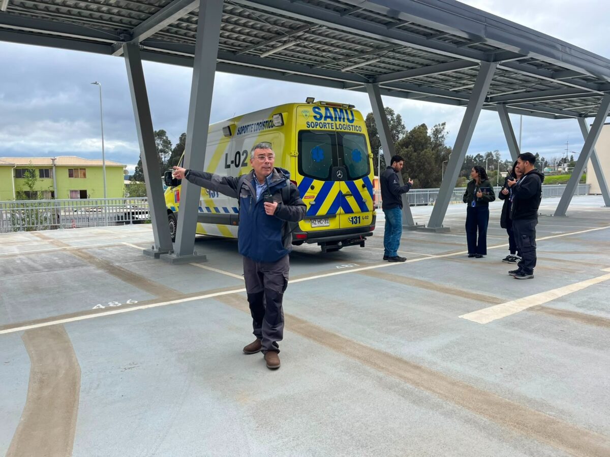 Funcionario instruye sobre el uso de equipos radiales junto a una ambulancia SAMU.