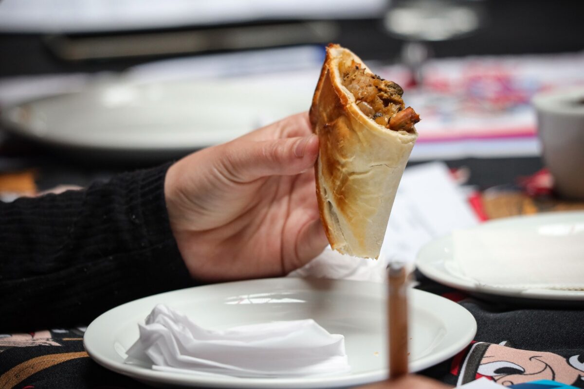 Detalle de una empanada siendo sostenida para su evaluación.
