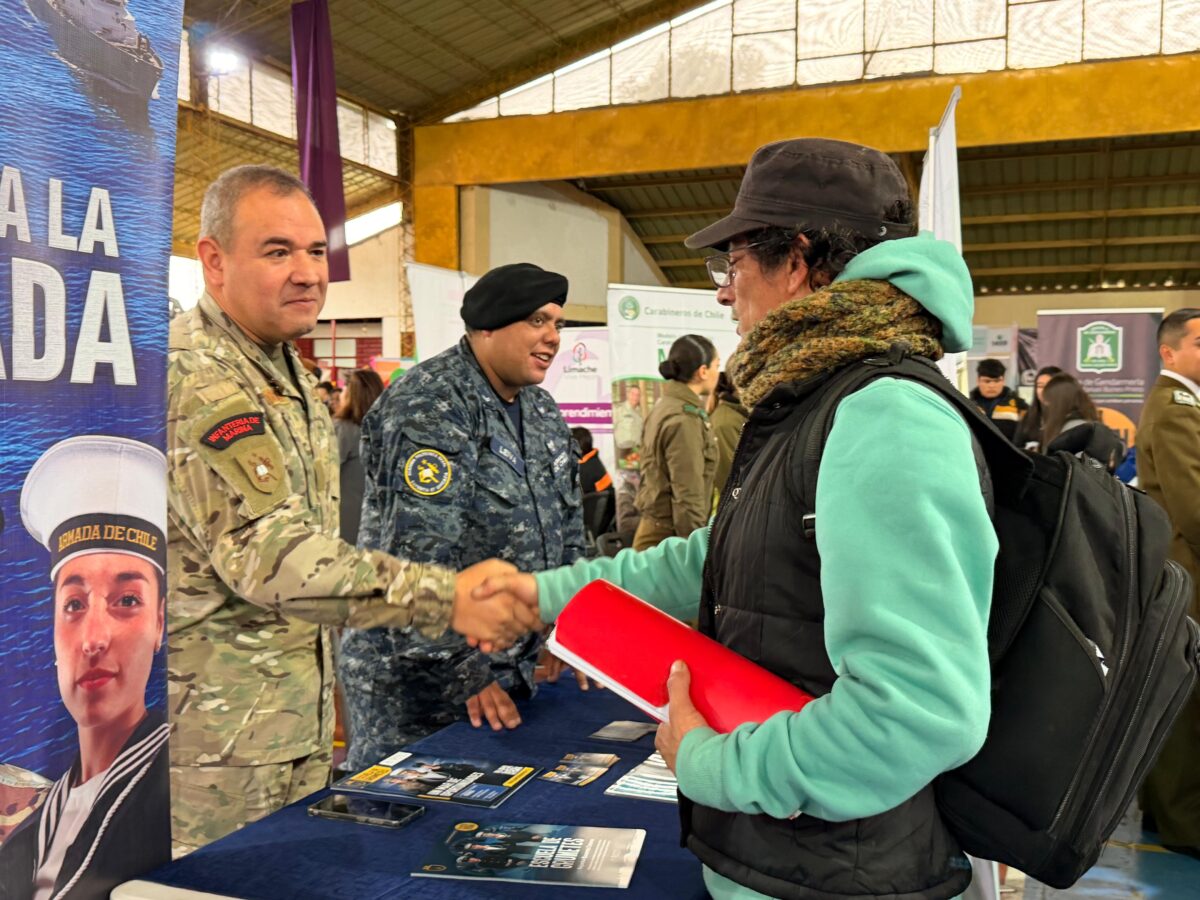 Representantes de la Armada de Chile orientando a una asistente en la feria.
