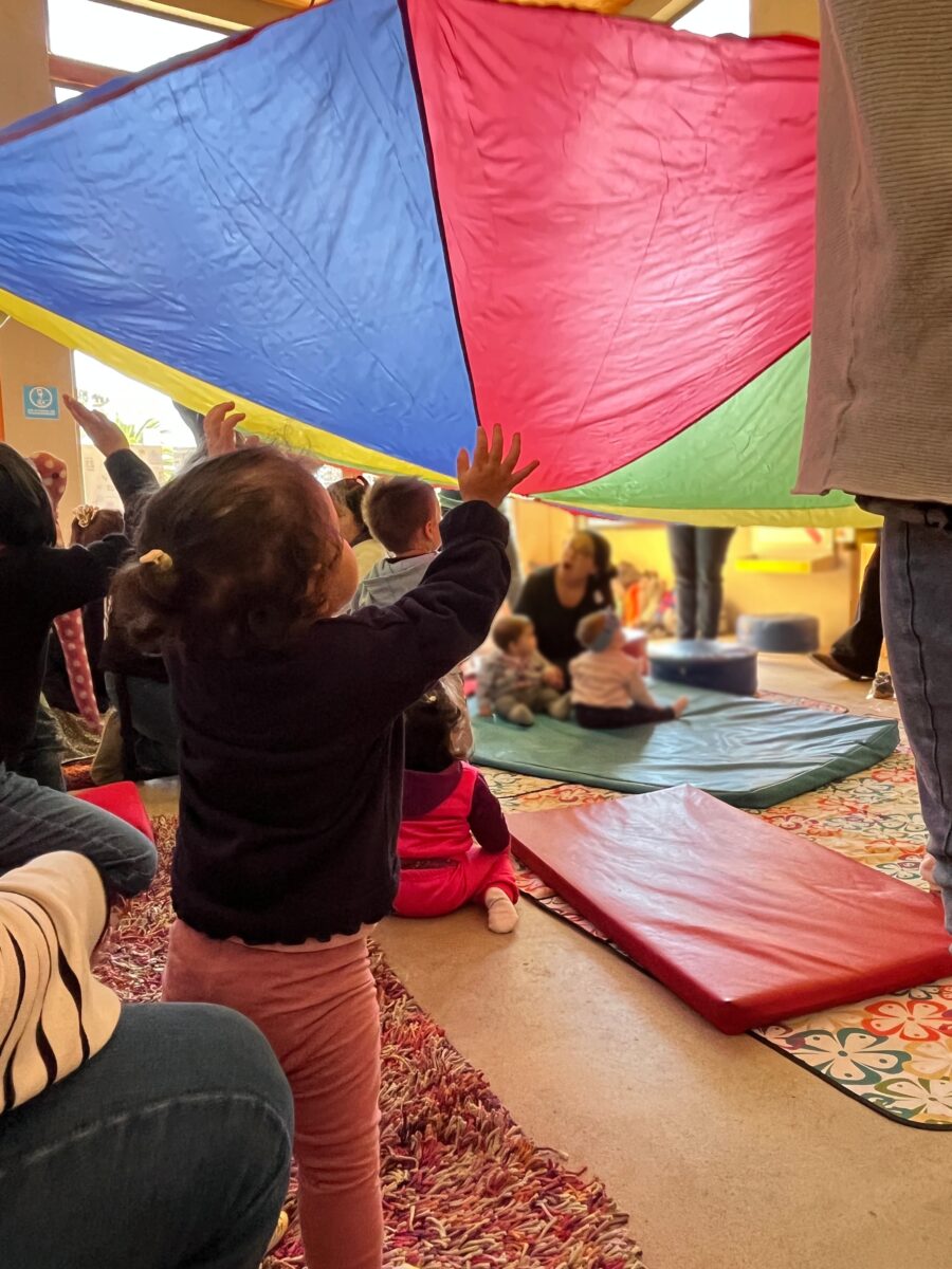 Niños explorando con telas de colores en una actividad sensorial en el museo Artequin.
