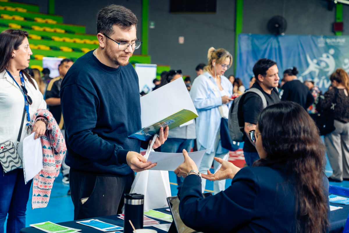 Postulante entregando su currículum en uno de los stands de la feria.